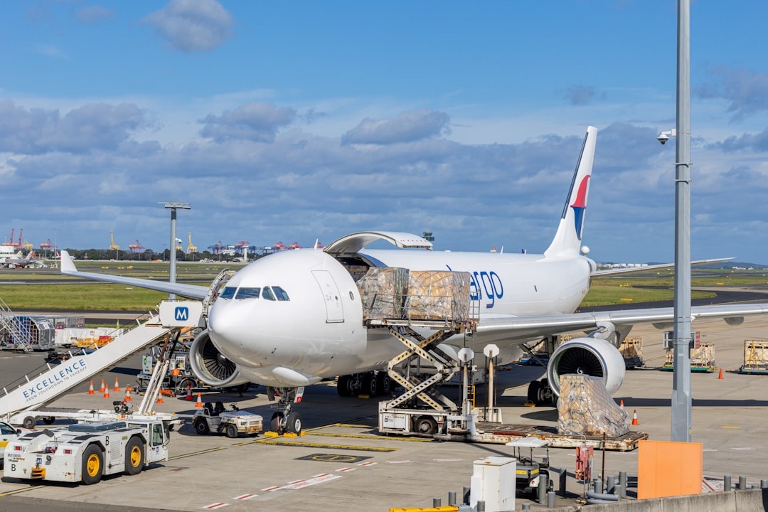 Cargo plane being loaded at an airport tarmac.